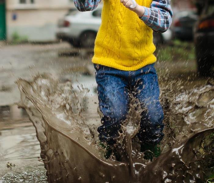 Kid Playing in flooded parking lot
