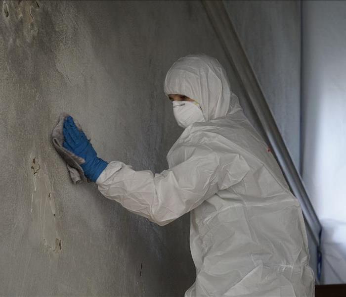 A man using a rag to remove soot damage
