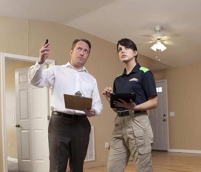 A man pointing next to a SERVPRO team member